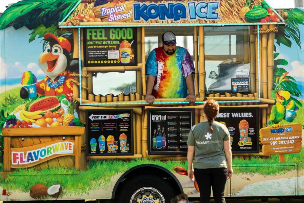 People peruse menus of food trucks during a pop-up food truck rally Saturday, Aug. 22, 2020 at the Midland Towne Center. (Cody Scanlan/for the Daily News)