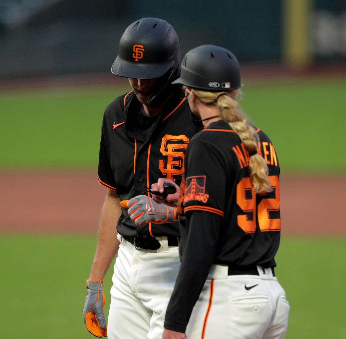 Mauricio Dubon and first base coach Alyssa Nakken walk back to the