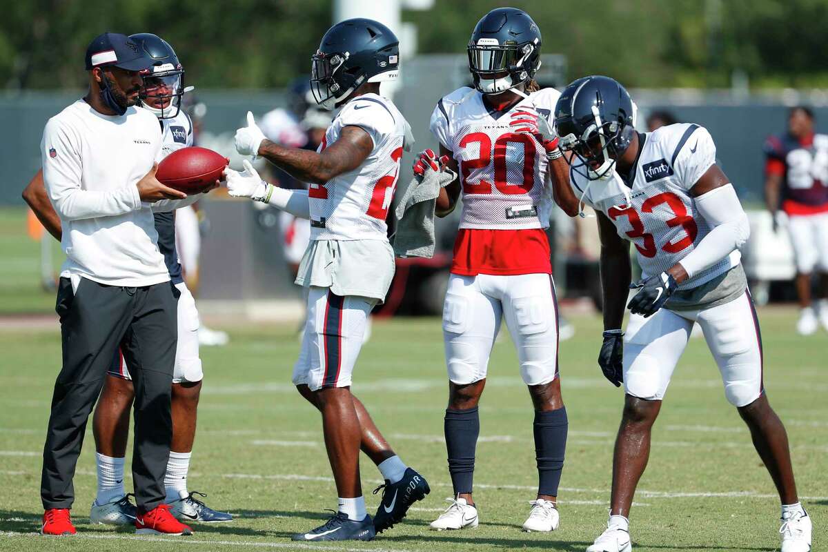 Houston Texans secondary coach D'Anton Lynn works with cornerback Gareon Conley (22), safety Justin Reid (20) and safety A.J. Moore Jr. (33) during an NFL training camp football practice Sunday, Aug. 23, 2020, in Houston.
