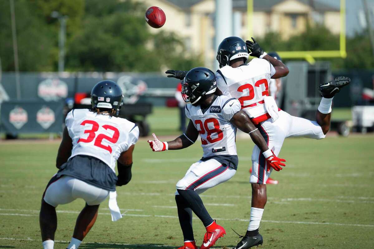 Houston Texans cornerback Lonnie Johnson Jr. (32), safety Michael Thomas (28) and safety Eric Murray (23) go after a ball during a drill at an NFL training camp football practice Sunday, Aug. 23, 2020, in Houston.