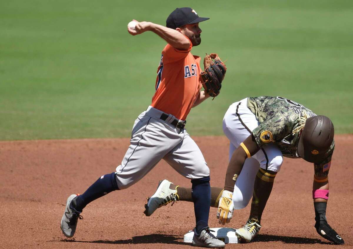 Houston Astros second baseman Jose Altuve, left, throws to first base after forcing out San Diego Padres' Fernando Tatis Jr. during the first inning of a baseball game in San Diego, Sunday, Aug. 23, 2020. Manny Machado was safe at first base. (AP Photo/Kelvin Kuo)