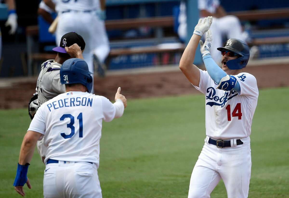 Kiké Hernandez mimics a basketball shot after hitting one of the Dodgers' seven homers Sunday.