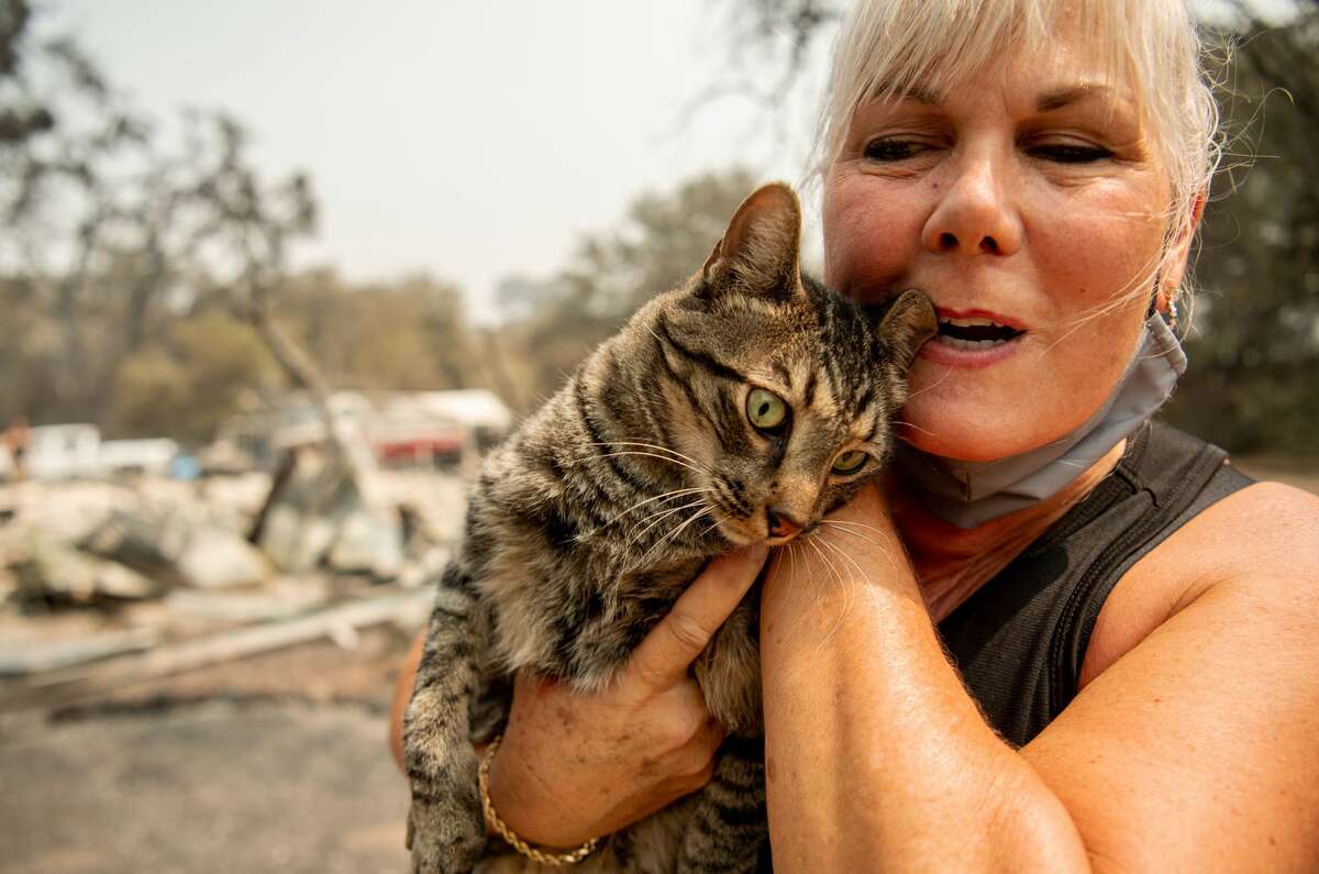 Resident Katie Giannuzzi reacts with joy as she finds her cat Gus in a drain amidst the burned remains of her home during the LNU Lightning Complex fire in Vacaville, California on August 23, 2020. - Firefighters battled some of California's largest-ever fires that have forced tens of thousands from their homes and burned one million acres, with further lightning strikes and gusty winds forecast in the days ahead. (Photo by JOSH EDELSON / AFP) (Photo by JOSH EDELSON/AFP via Getty Images)