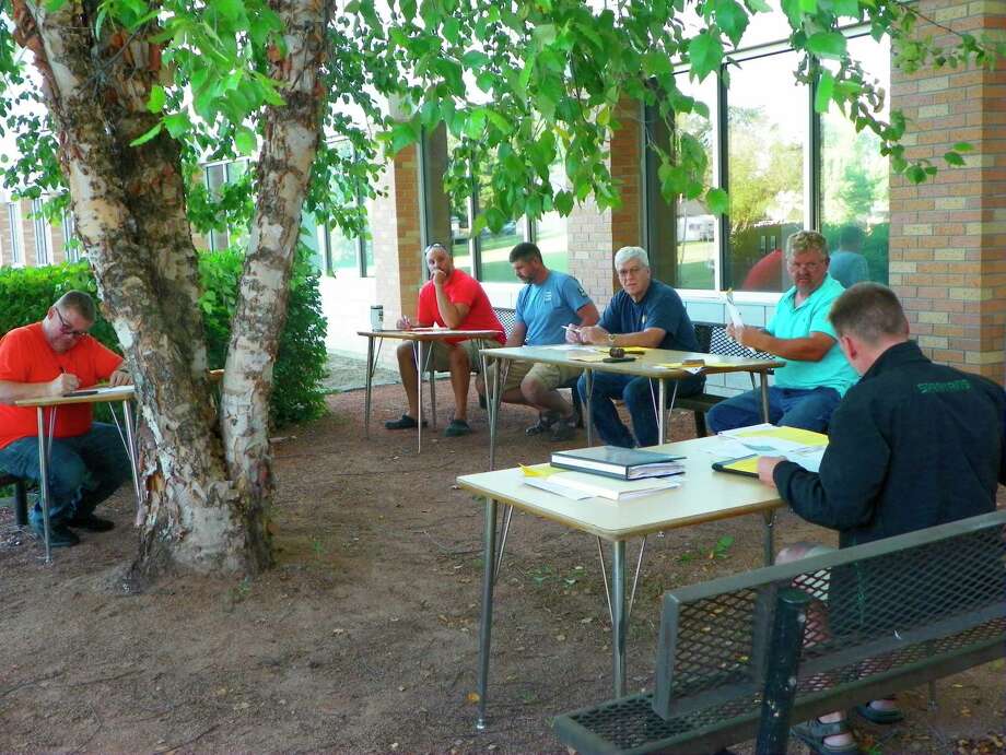 The Harbor Beach School Board meets outside due to coronavirus precautions during their recent board of education meeting. (Rich Harp/For the Tribune)