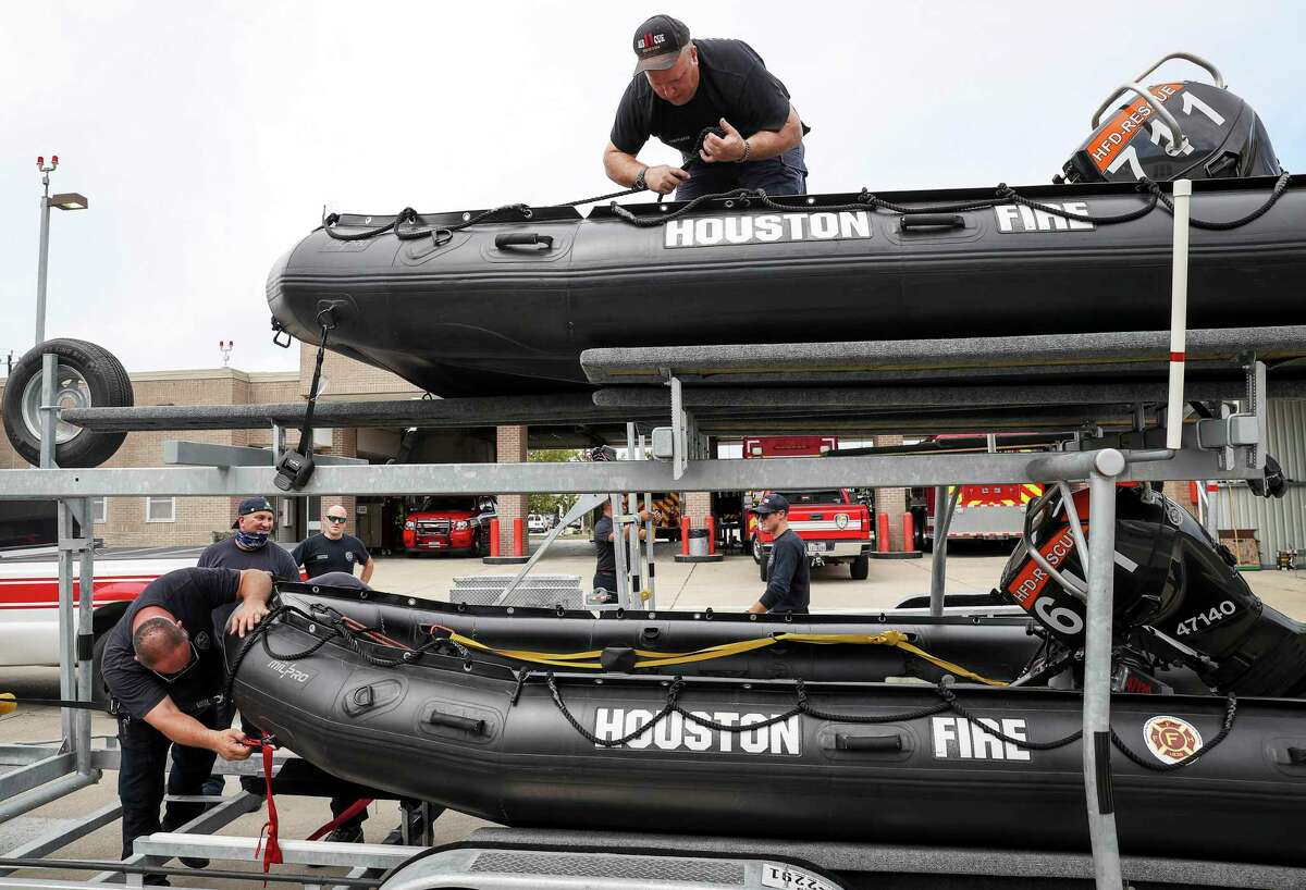 Engineer Operator Karl Carmack, left, Firefighter Paul Kessler, top, and other firefighters from Houston Fire Station 11 prepare water-rescue equipment Monday, Aug. 24, 2020, at HFD Station 11 in Houston.