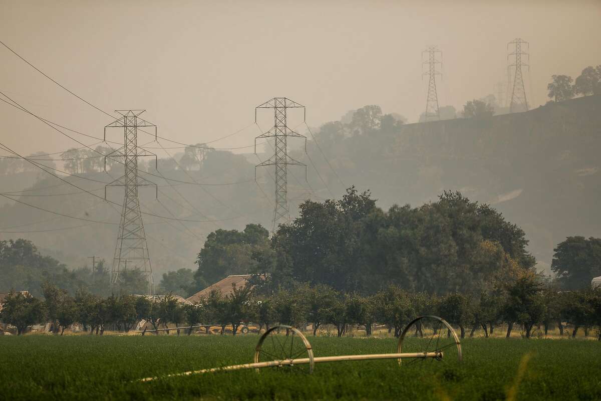 Smoke and haze surround power lines in Vacaville after the LNU Lightning Complex fire tore through the area on Monday, Aug. 24, 2020 in Vacaville, California.