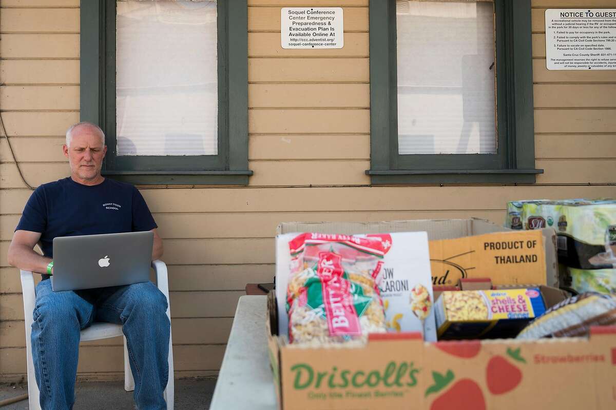 Mike Heffner, Superintendent-Principal of the Bonny Doon Union Elementary School District, works on his laptop at the 7th Day Adventist church evacuation center in Soquel, Calif. on Aug., 24, 2020.