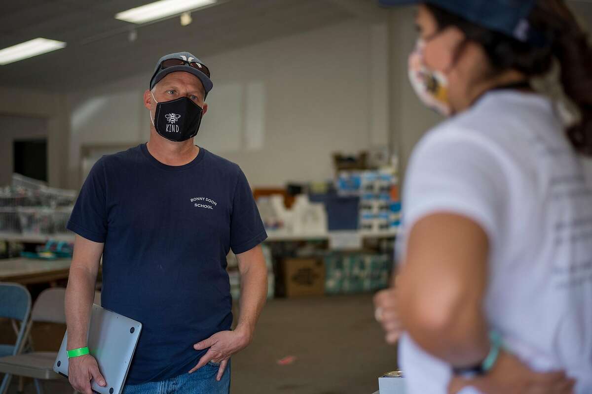 Mike Heffner, Superintendent-Principal of the Bonny Doon Union Elementary School District, (left) talks with Santa Cruz County disaster service worker Monica Hernandez at the 7th Day Adventist church evacuation center in Soquel, Calif. on Aug., 24, 2020.