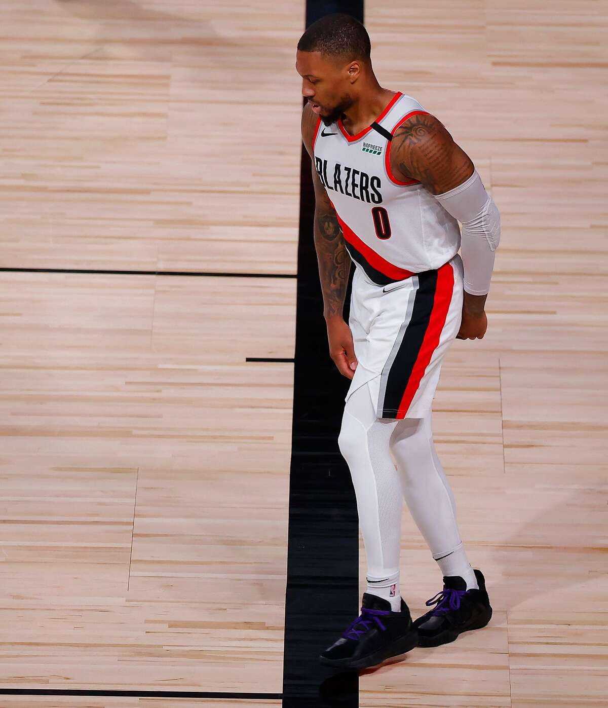 LAKE BUENA VISTA, FLORIDA - AUGUST 24: Damian Lillard #0 of the Portland Trail Blazers limps after drawing a foul against the Los Angeles Lakers during the third quarter in Game Four of the Western Conference First Round during the 2020 NBA Playoffs at AdventHealth Arena at ESPN Wide World Of Sports Complex on August 24, 2020 in Lake Buena Vista, Florida. NOTE TO USER: User expressly acknowledges and agrees that, by downloading and or using this photograph, User is consenting to the terms and conditions of the Getty Images License Agreement. (Photo by Kevin C. Cox/Getty Images)