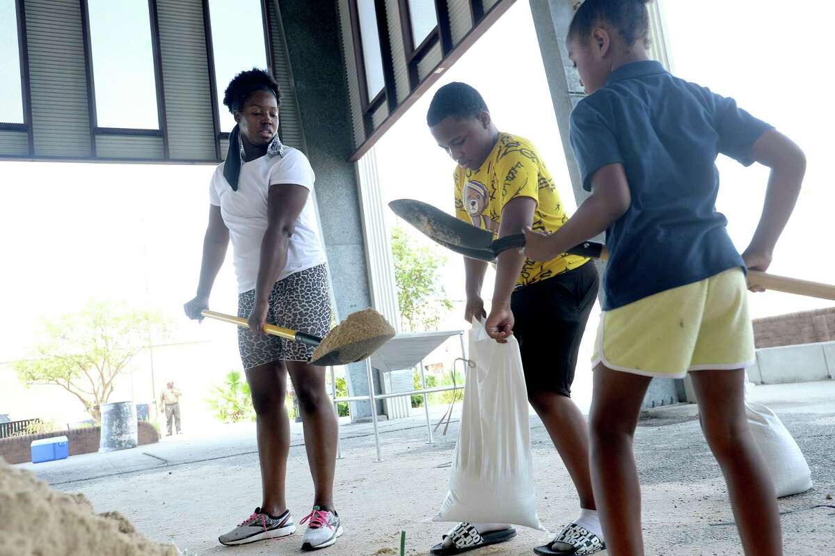 The pavilion in Port Arthur is filled with sandbaggers, including Shaketha Fontenette, with nephew Dakovin Martin and daughter Alexandra Johnnson, as area residents prepare for Marco and Laura's hit to the region this week. Photo taken Monday, August 24, 2020 Kim Brent/The Enterprise