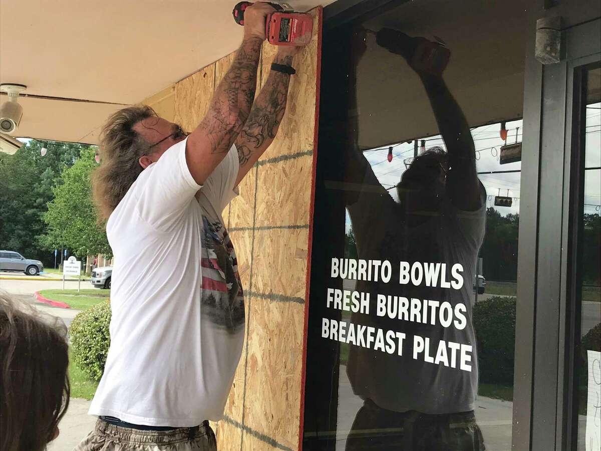 Fred Collins, 61, screws plywood to cover windows on the Donut Palace along Texas 87 north of downtown Orange, Texas, on Aug. 25, 2020. Orange County officials ordered a mandatory evacuation as Hurricane Laura threatens the northern Texas Gulf Coast.