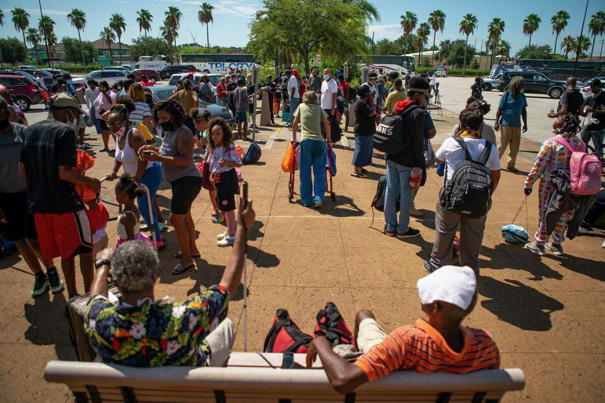 People wait in front of the Galveston Housing Authority offices to board charter busses that will evacuate them from Galveston Island to Austin in anticipation of impact from Hurricane Laura, Tuesday, Aug. 25, 2020, in Galveston.