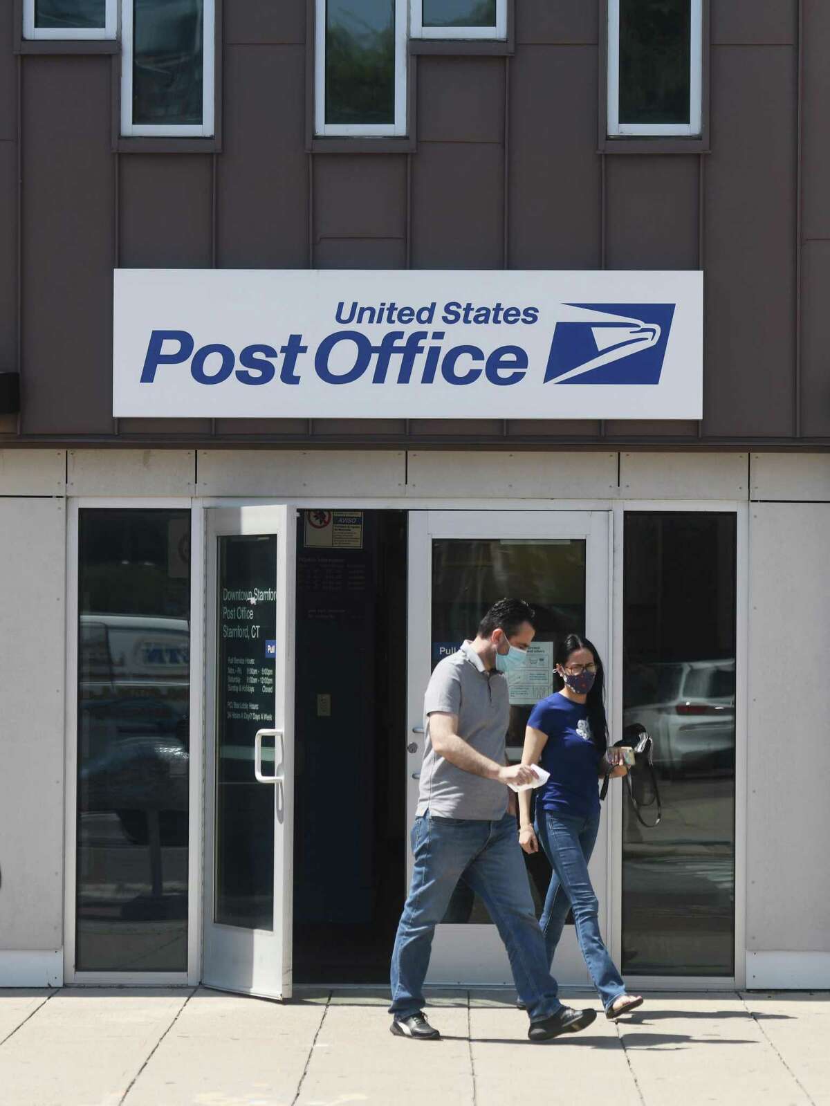 Customers exit the U.S. Post Office on Summer Street in Stamford, Conn. Monday, Aug. 17, 2020. Starting in mid-September, the Secretary of the State will mail absentee ballot applications to all registered voters in Connecticut. Those who wish to vote by mail on Nov. 3 must fill out and return the application. Once applications are verified, voters will be mailed ballots beginning Oct. 2. If you prefer, you may send in an application now. This is the link for downloading an application. By Connecticut law, the secretary of the state cannot begin sending absentee ballots to voters until Oct. 2. Voters should fill them out and mail them to the town clerk as quickly as possible. (Unlike ballot applications, ballots cannot be downloaded.) Absentee ballot applications and ballots also may be placed in one of two official drop boxes. One box is in the parking garage of the Stamford Government Center, 888 Washington Blvd., near the lobby doors. The other is in front of Ferguson Library’s Harry Bennett Branch, 115 Vine Road.