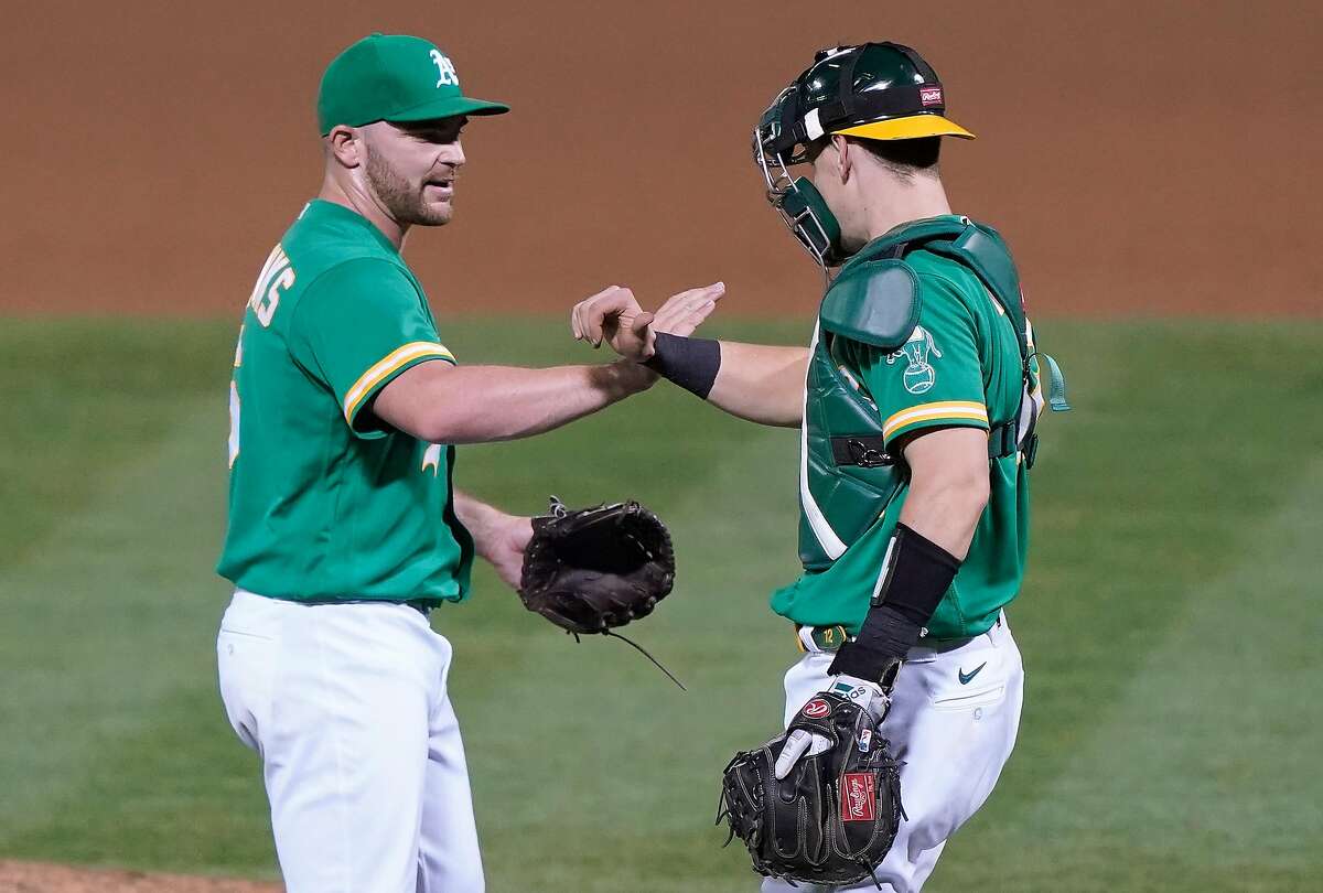 OAKLAND, CALIFORNIA - AUGUST 21: Liam Hendriks #16 and Sean Murphy #12 of the Oakland Athletics celebrate after defeating the Los Angeles Angels 5-3 at RingCentral Coliseum on August 21, 2020 in Oakland, California. (Photo by Thearon W. Henderson/Getty Images)