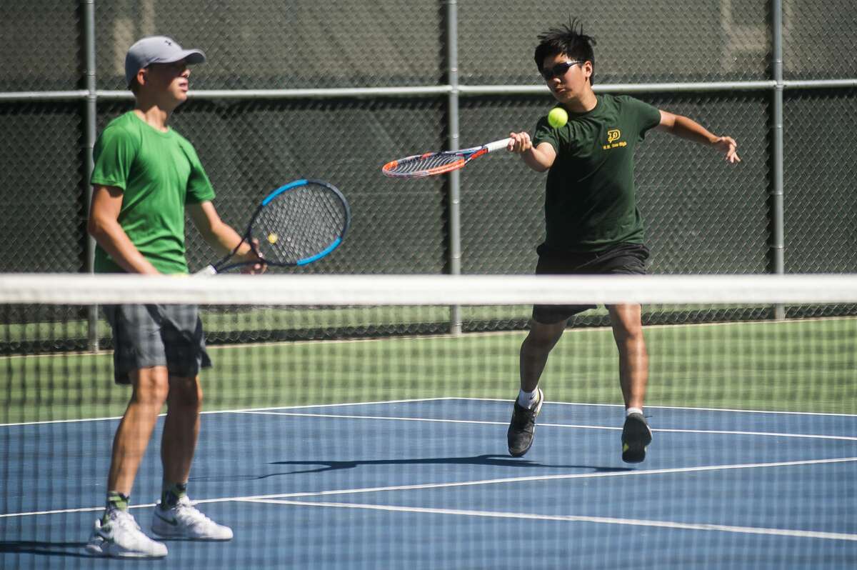 Dow's Logan Yu returns the ball as his partner Thomas Ladwein watches on during their No. 2 doubles match against Gibraltar Carlson Tuesday, Aug. 25, 2020 at the Greater Midland Tennis Center. (Katy Kildee/kkildee@mdn.net)