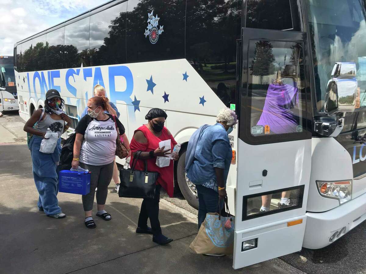 Orange County residents board charter buses ferrying them from the Texas Gulf Coast as Hurricane Laura approaches Orange, on the Louisiana border, on Aug. 25. County officials ordered a mandatory evacuation and coordinated bus rides for those unable to leave on their own.