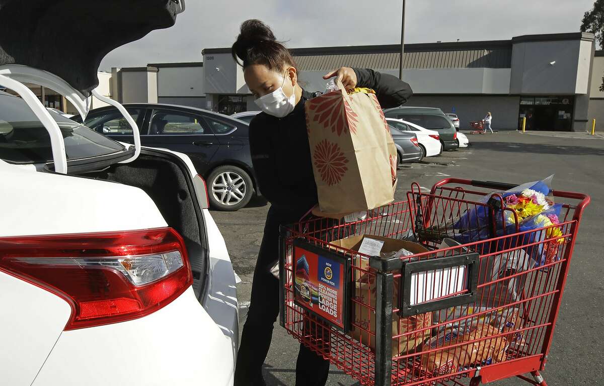 Instacart worker Saori Okawa loads groceries into her car in San Leandro in July. Instacart is raising fees to pay for the additional costs of non-employee benefits for drivers under California’s Proposition 22.