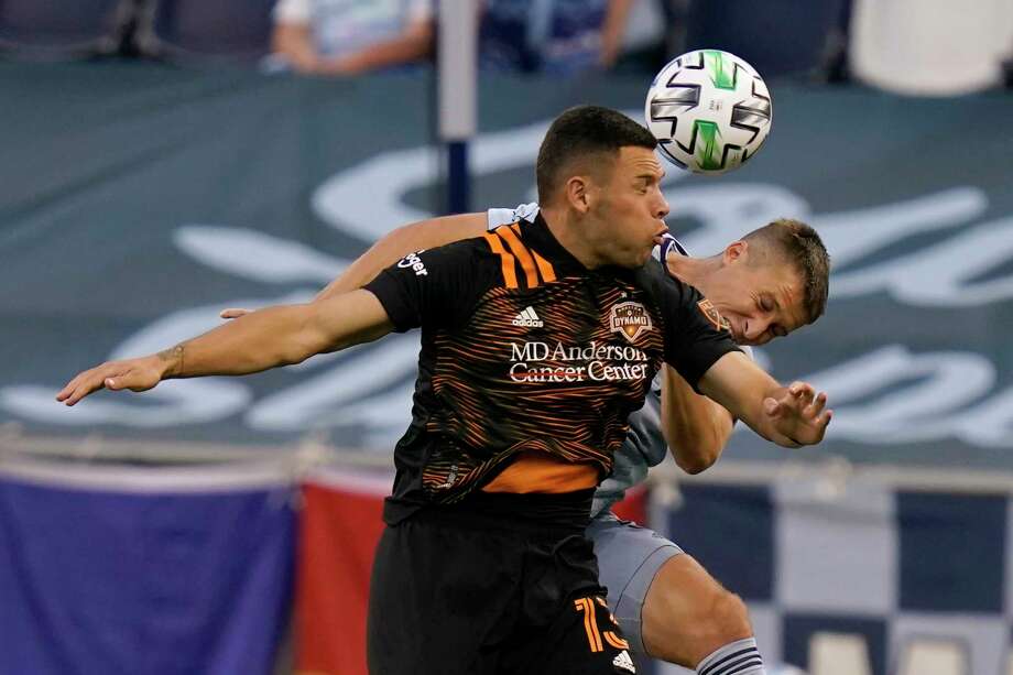 Houston Dynamo forward Christian Ramirez, left,  heads the ball against Sporting Kansas City defender Matt Besler, right, during the first half of an MLS soccer match in Kansas City, Kan., Tuesday, Aug. 25, 2020. (AP Photo/Orlin Wagner) Photo: Orlin Wagner, Associated Press / Copyright 2020 The Associated Press. All rights reserved