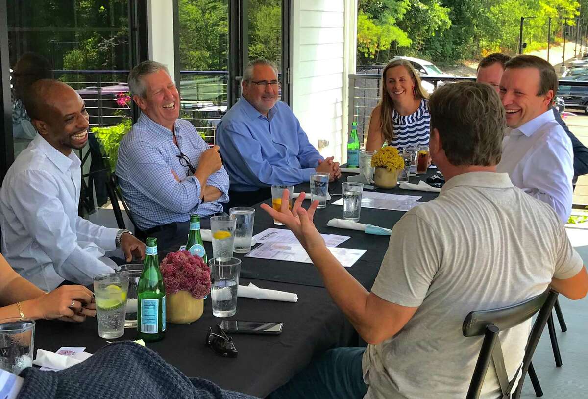 Restaurant owners and managers met with Sen. Chris Murphy, right, at the Wood-n-Tap in Farmington Tuesday, August 25, 2020. Also pictured, a lunch crowd at the Wood-n-tap under a tent on the Farmington River.