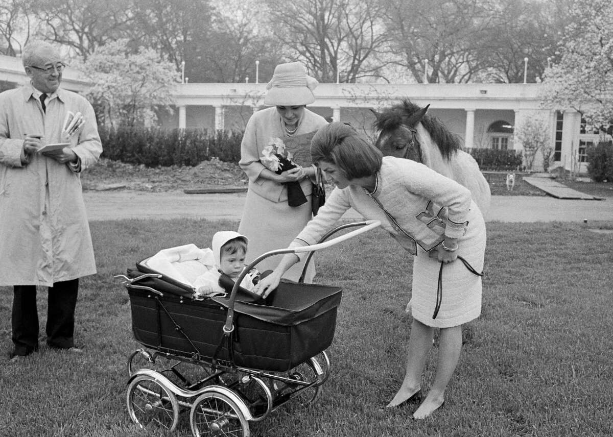 1962: Jacqueline Kennedy with John Jr. First lady Jackie Kennedy was involved in overseeing the renovations of the garden and documented the process in a scrapbook kept by the White House Historical Association. In this photo, dated April 12, 1962, we see Jackie Kennedy with her son, John, and Empress Farah, wife of the shah of Iran, along with the Kennedy pony, Marconi, on a tour of the White House grounds. In the background, the garden renovation is underway.