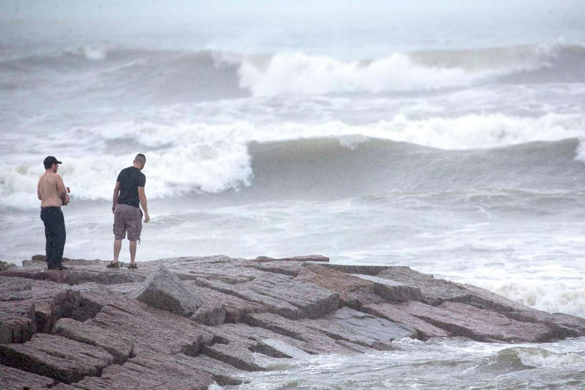 Alex Mazzucco, left, and Nathan Wilson stand out on a jetty watching the surf stirred up by Hurricane Laura on Wednesday, Aug. 26, in Galveston.