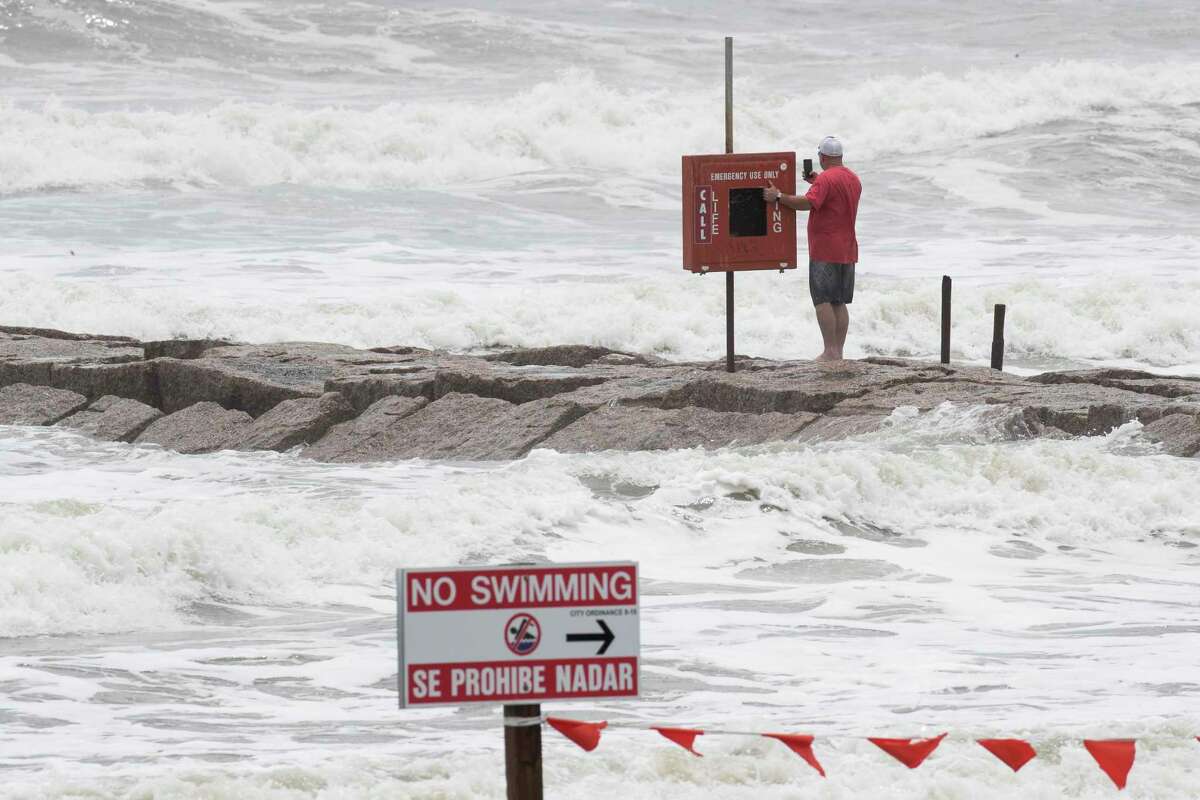 People watch the surf stirred up by Hurricane Laura while walking on a jetty Wednesday, Aug. 26, 2020 in Galveston.
