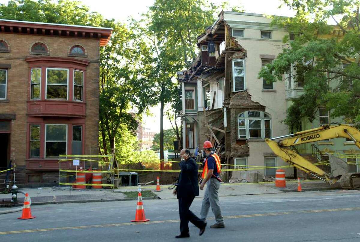 Albany Fire Chief Robert Forezzi Sr., left, walks by 600 Madison Ave., right, where a wall collapsed on Friday, Aug. 27, 2010, in Albany. (Cindy Schultz / Times Union)