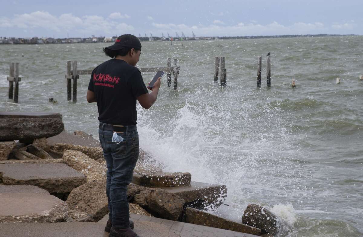 An Ichibon Japanese Steakhouse worker doing a video of the waves after work and before Hurricane Laura makes landfall Wednesday, Aug. 26, 2020, in Kemah.
