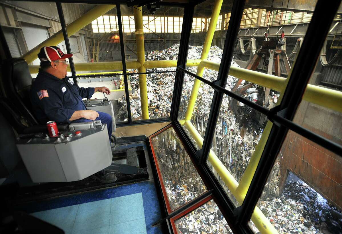 Overhead crane operator Luis Rullan guides a giant claw to pick up trash at Wheelabrator's Bridgeport Resco waste-to-energy plant in Bridgeport in 2013.