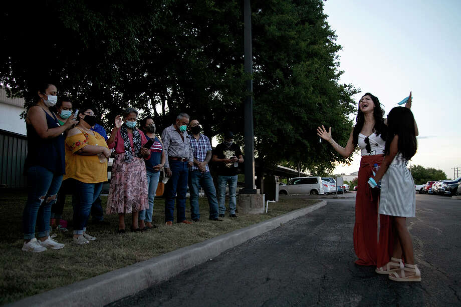 Susie Medrano, with daughter Alexis Martinez, sings at the conclusion of a prayer for Nora, her great-aunt, July 23 outside San Antonio’s Southwest General Hospital. Nora's husband and four children were joined by others in praying for her for close to an hour. Photo: Lisa Krantz/Staff Photographer / San Antonio Express-News