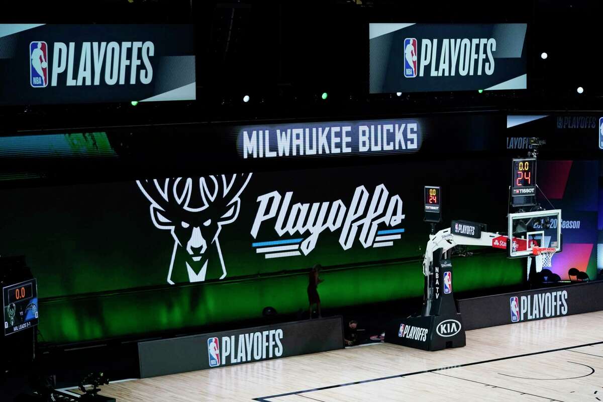Milwaukee Bucks signage is displayed on screens beside an empty court before the scheduled start of an NBA basketball first round playoff game between the Milwaukee Bucks and the Orlando Magic, Wednesday, Aug. 26, 2020, in Lake Buena Vista, Fla. (AP Photo/Ashley Landis, Pool)