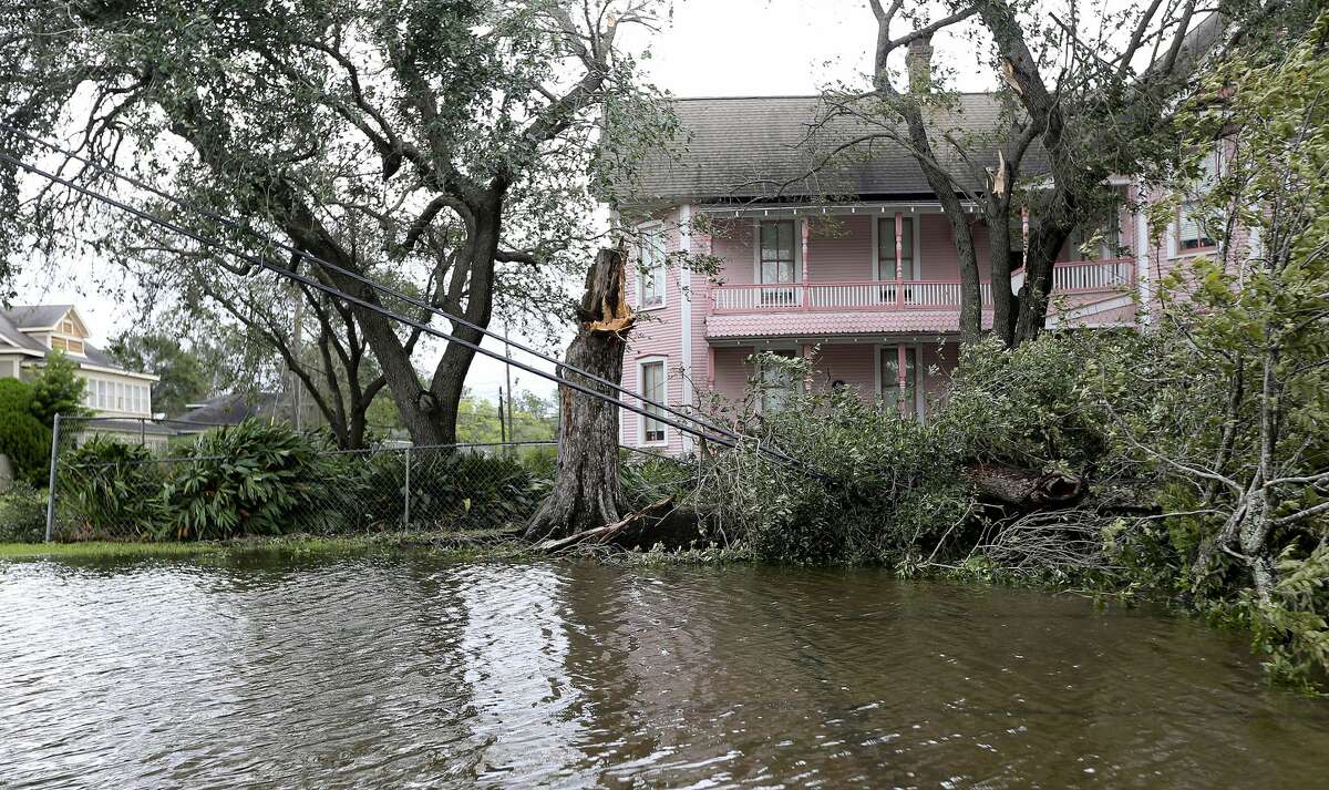 A flooded street and downed power lines from Hurricane Laura in front of a historic home in Orange, Texas on Thursday, Aug. 27, 2020.
