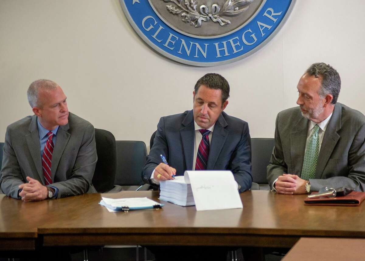 Texas Comptroller Glenn Hegar, center, certifies the 2020-21 state budget as Associate Deputy Comptroller for Fiscal Matters Phillip Ashley, left, and Director of Fiscal Management Rob Coleman, right, look on in this file photo from 2019.