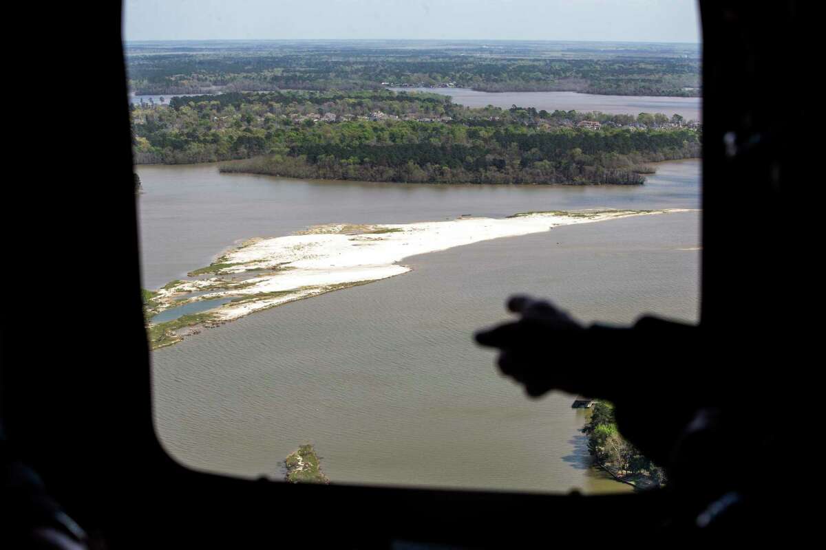 A sand bar can been seen from a helicopter window as Dave Martin, Houston city councilman, District E, left, speaks to Gov. Greg Abbott during an aerial tour over the San Jacinto River, downstream from Lake Conroe, on Thursday, March 15, 2018, in Houston. The Kingwood area suffered serious flooding during Hurricane Harvey due in part to sand washed downstream from sand mining operations along the river. ( Brett Coomer / Houston Chronicle )