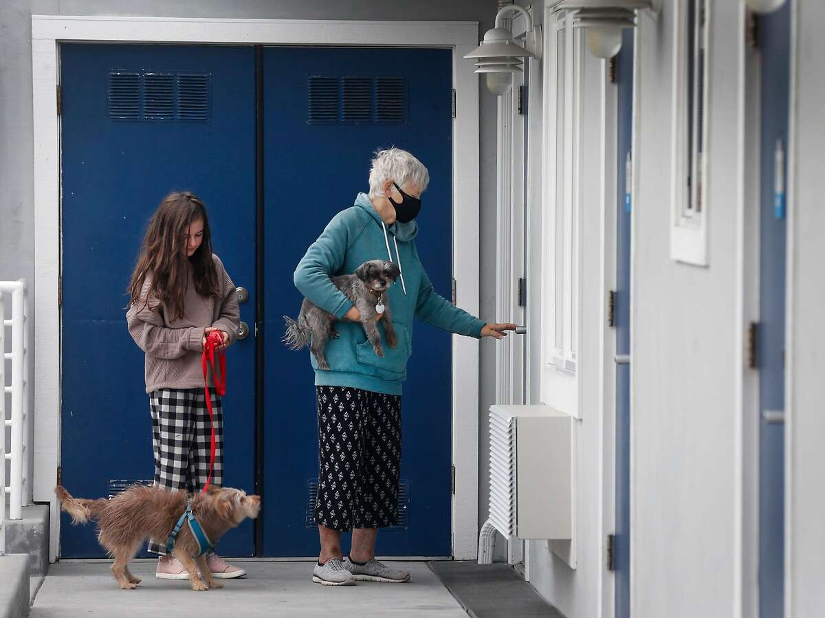 Marie Stefanesko and her granddaughter Lily Katznelson, 11, return to their hotel room at the Beach Street Inn and Suites while the family waits for evacuation orders to be lifted in Santa Cruz, Calif. on Thursday, Aug. 27, 2020. Hotels have experienced a spike in occupancies after welcoming local residents that have been temporarily displaced by wildfires.