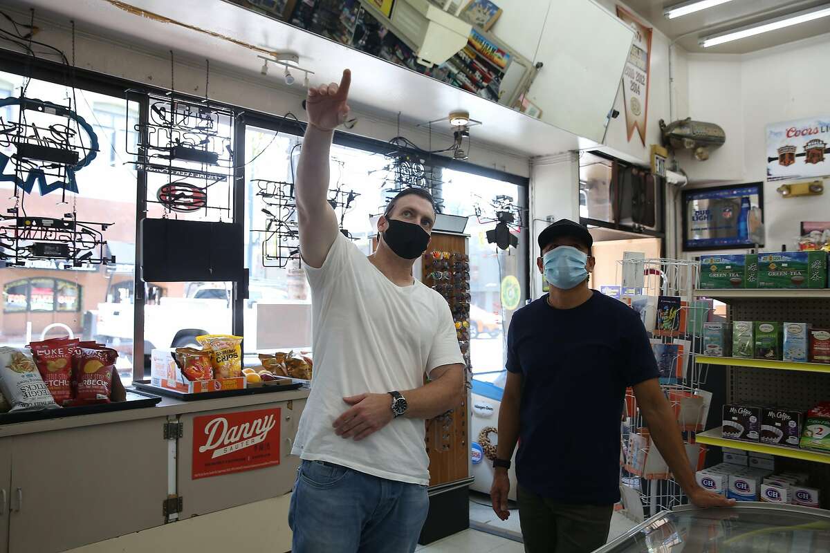 Jeffrey Choate (l to r) talks with Discount Grocers owner Warren Trinidad (left) who he was meeting with to talk about painting a mural in the store on Tuesday, August 18, 2020 in San Francisco, Calif.