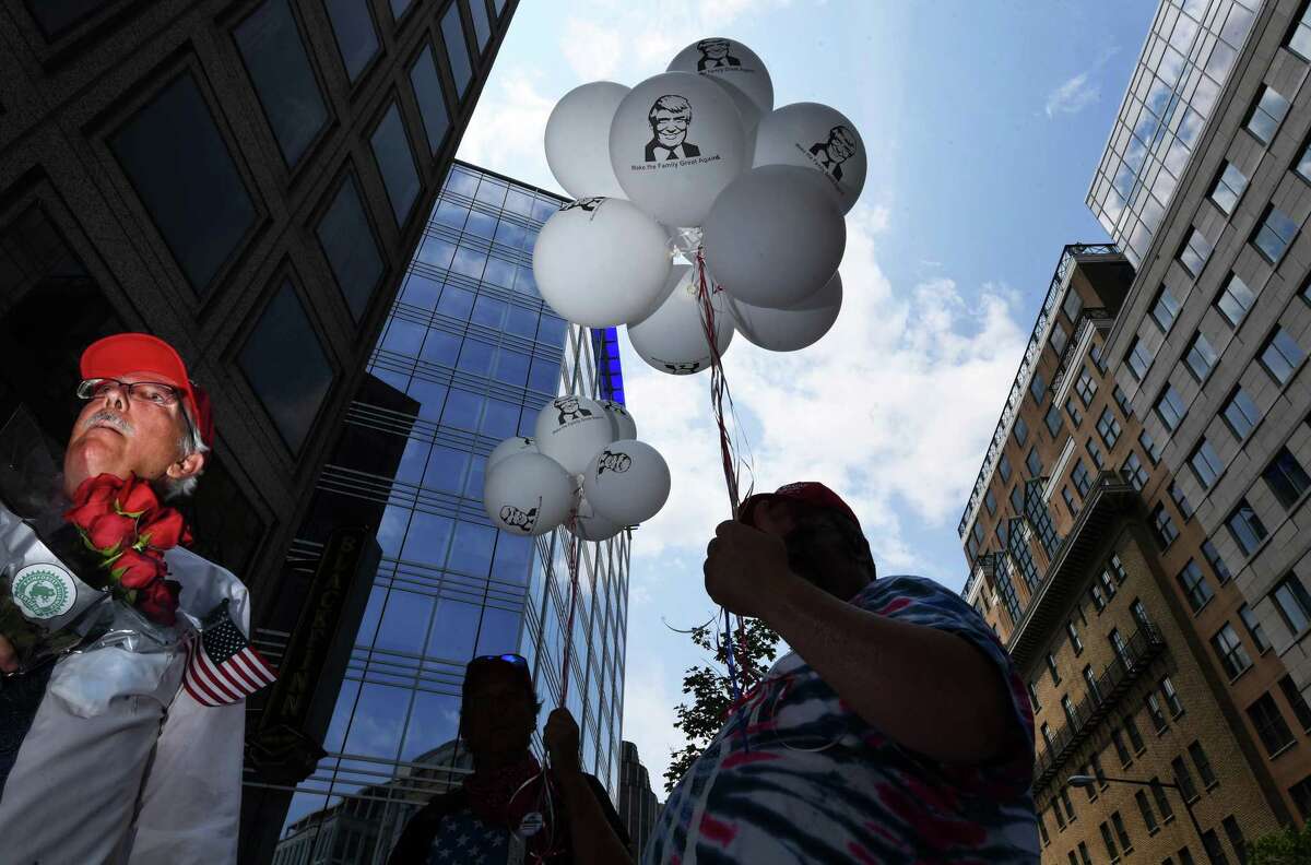 People carry balloons with President Trump's image on them following an event near the White House by the religious conservative group Public Advocate of the United States, hours before Trump was to accept the Republican nomination in a South Lawn speech.
