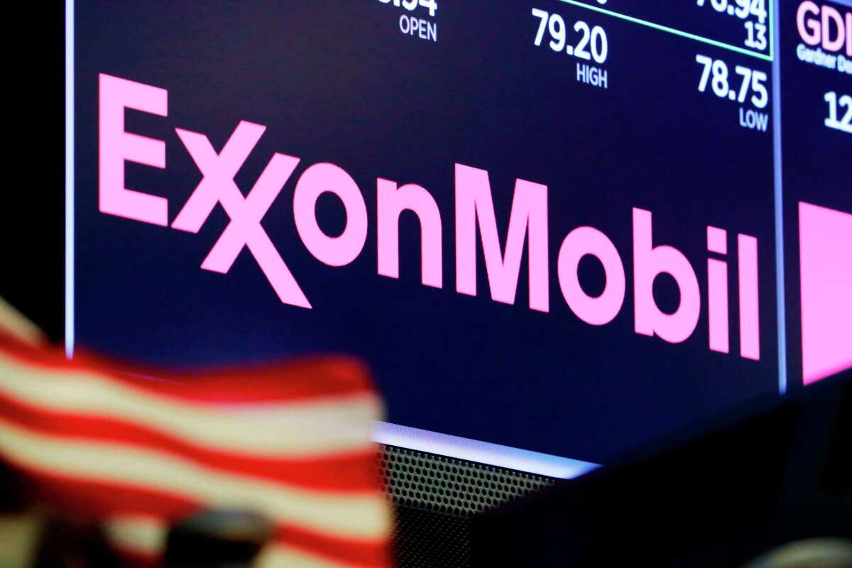 The logo for ExxonMobil appears above a trading post on the floor of the New York Stock Exchange. Exxon lost $1.1 billion in the second quarter, Friday, July 31, 2020, its economic pain deepening as the pandemic kept households on lockdown, diminishing the need for oil around the world.