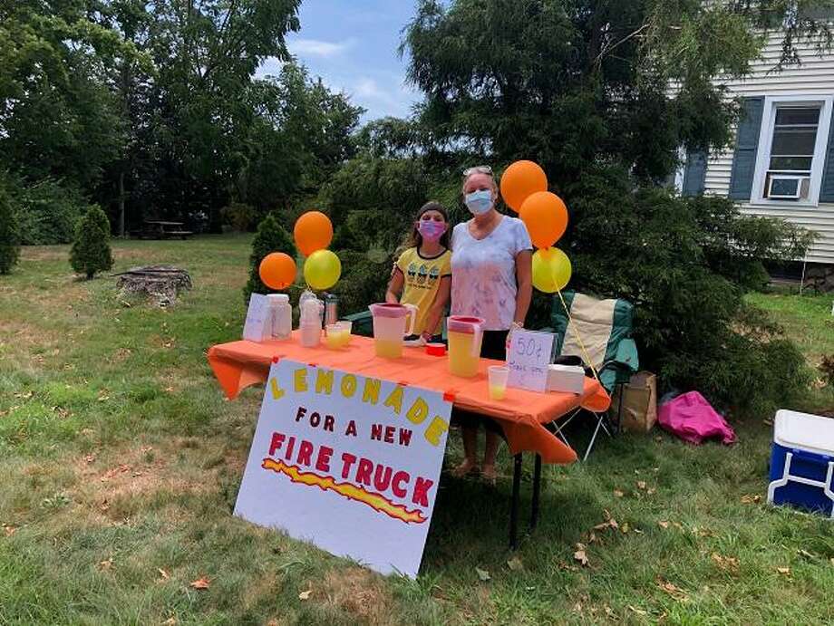 Kalina Duz, left, and her mother, Aneda Kratzer-Duz, at the lemonade stand they are operating to raise money toward the Orange Volunteer Fire Department’s “Fire Truck 50K Challenge.” Photo: Jim Leahy / Contributed Photo