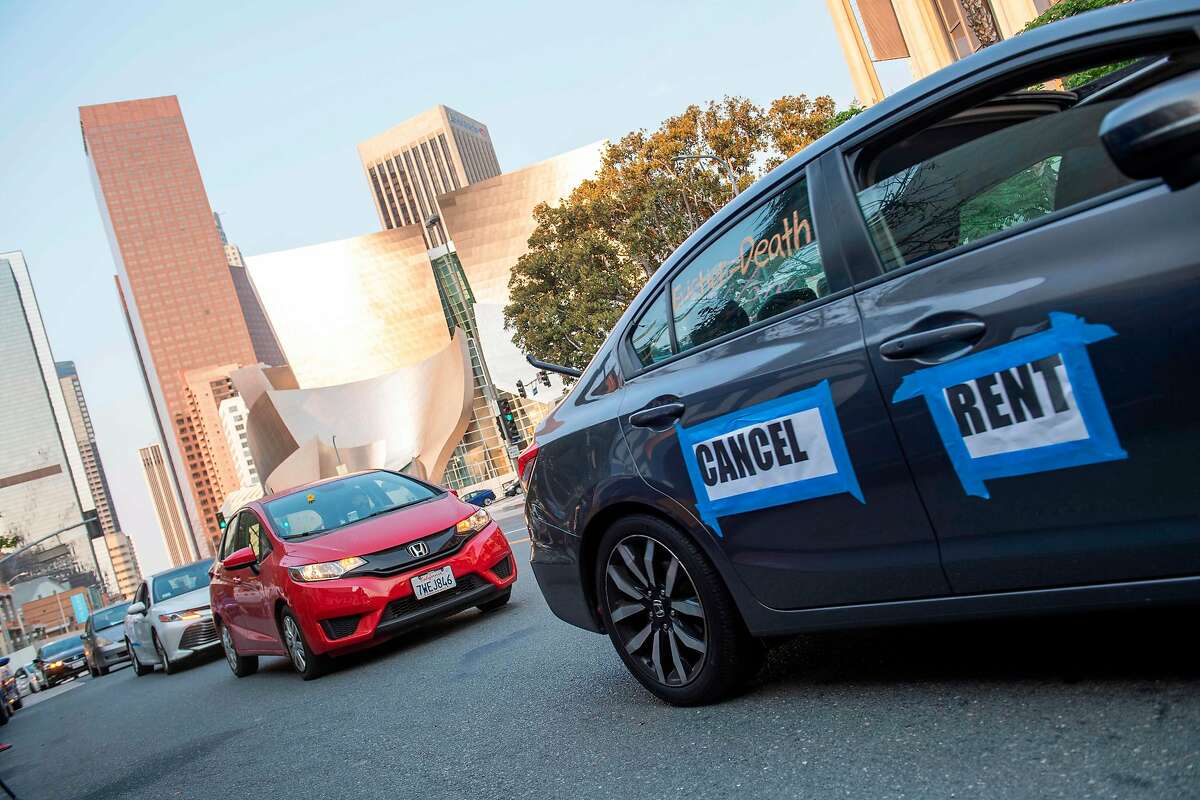 Cars with sign 'Cancel Rent' are seen driving around downtown LA during a protest to cancel rent and avoid evictions amid Coronavirus pandemic on August 21, 2020, in Los Angeles, California. (Photo by VALERIE MACON / AFP) (Photo by VALERIE MACON/AFP via Getty Images)