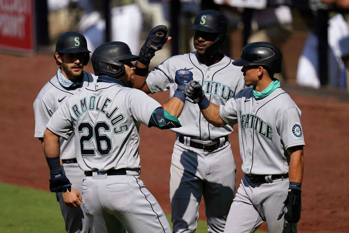 Seattle Mariners' Jose Marmolejos (26) is greeted by teammates Austin Nola, left, Kyle Lewis, second from right, and Sam Haggerty, right, after hitting a grand slam during the first inning of a baseball game against the San Diego Padres, Thursday, Aug. 27, 2020, in San Diego. (AP Photo/Gregory Bull)