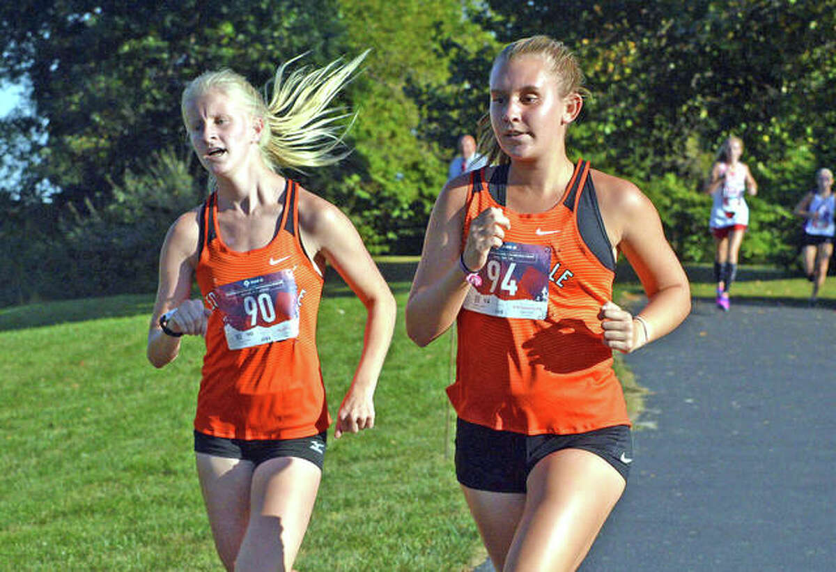 Edwardsville’s Arabella Ford, left, and Kaitlyn Loyet run in the large-school girls race at the Madison County Meet at Belk Park in Wood River.