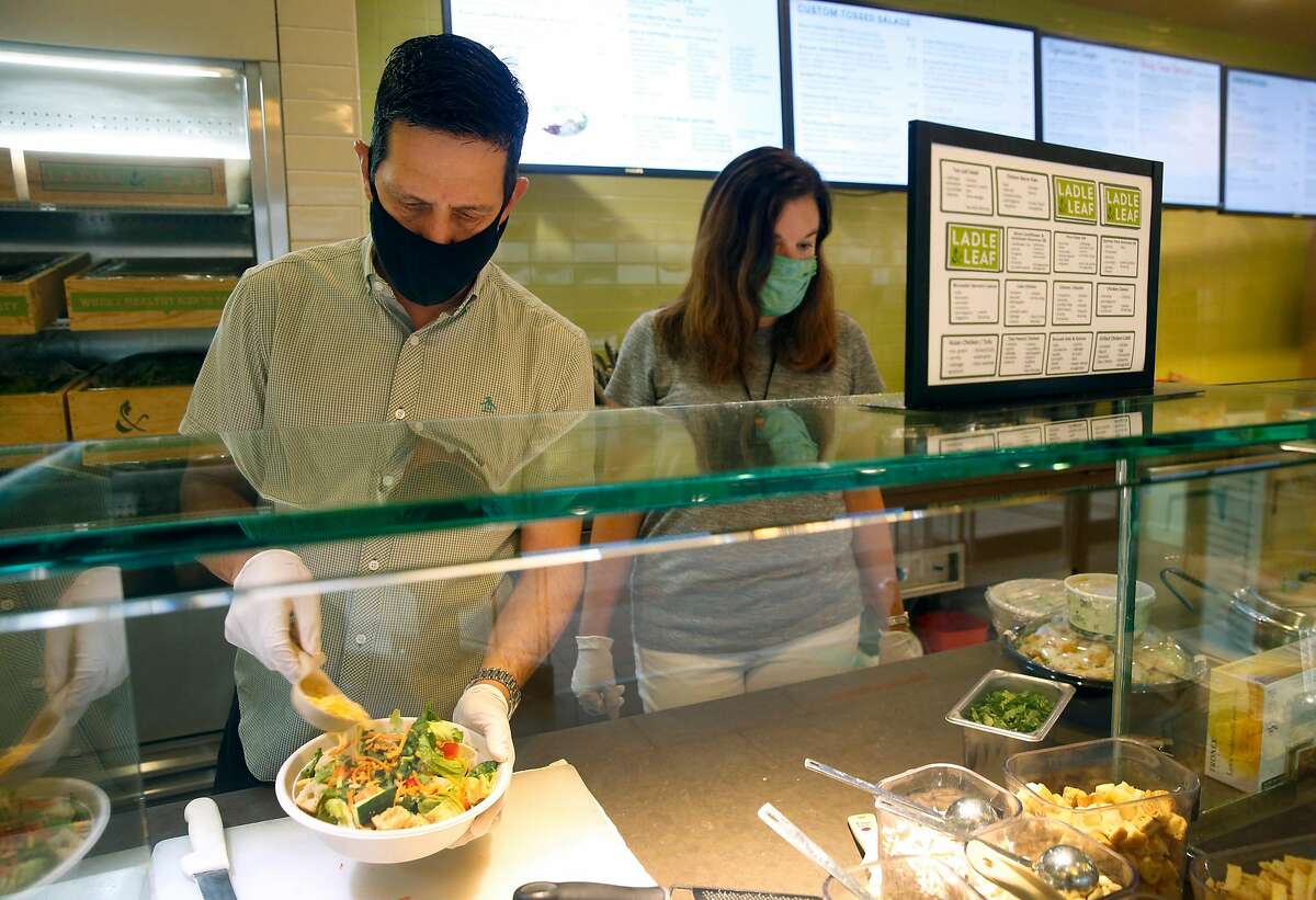 Steve Sarver prepares a salad with business partner Jennifer Sarver at their Ladle and Leaf cafe and restaurant in the Crocker Galleria mall in San Francisco, Calif. on Tuesday, Aug. 25, 2020. Some businesses have remained open despite few office workers and commuters populating the Financial District during the coronavirus shutdown.