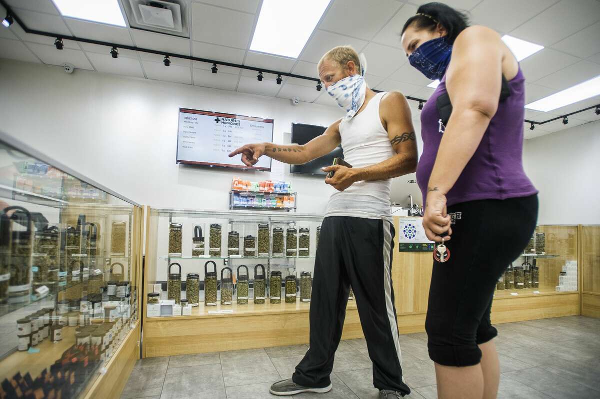 Midland residents Burke McCain, center, and Shanon Lucier, right, select which marijuana strains they will purchase Friday, Aug. 28, 2020 at Nature's Medicines Dispensary, located at 3480 E. North Union Rd. in Bay City. (Katy Kildee/kkildee@mdn.net)