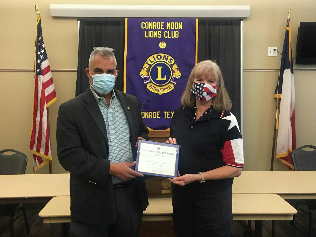 Conroe Noon Lions Club President, Rafael Perez, left, congratulates Lion Connie McNabb, right, the club’s Lion of the Month for July, for her photography efforts at the blood drive, Tacos for Teachers, and our Service Saturday Project.