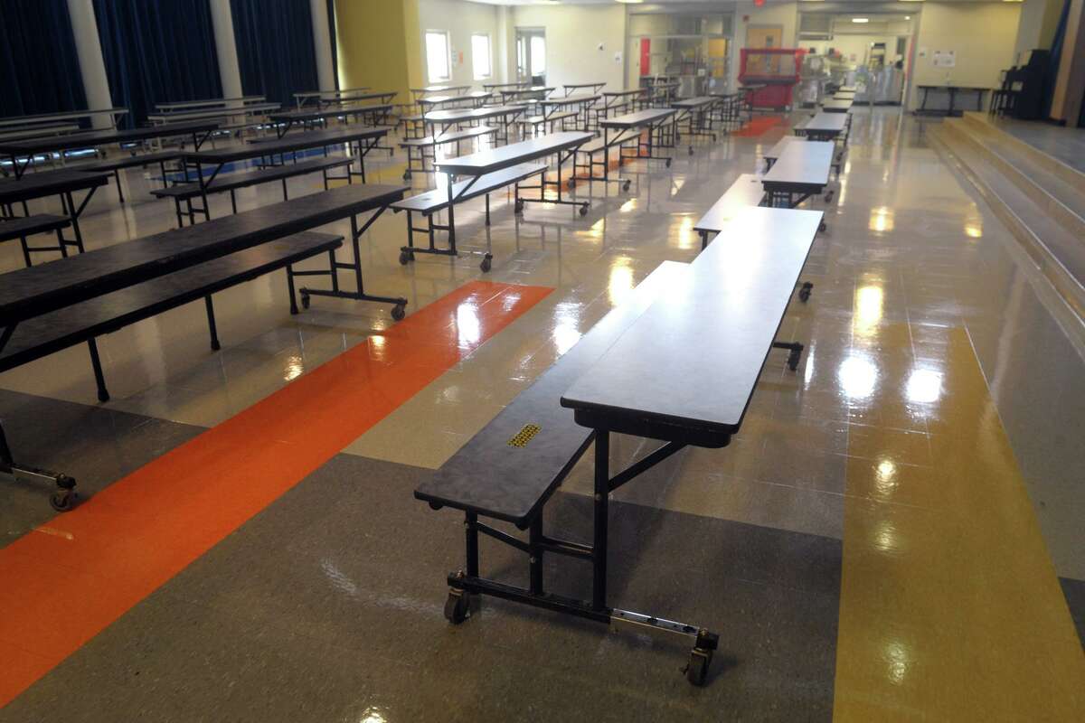 Cafeteria tables have been cut half at Johnson School so that students will all sit facing in one direction, seen here in Bridgeport, Conn. Aug. 27, 2020.