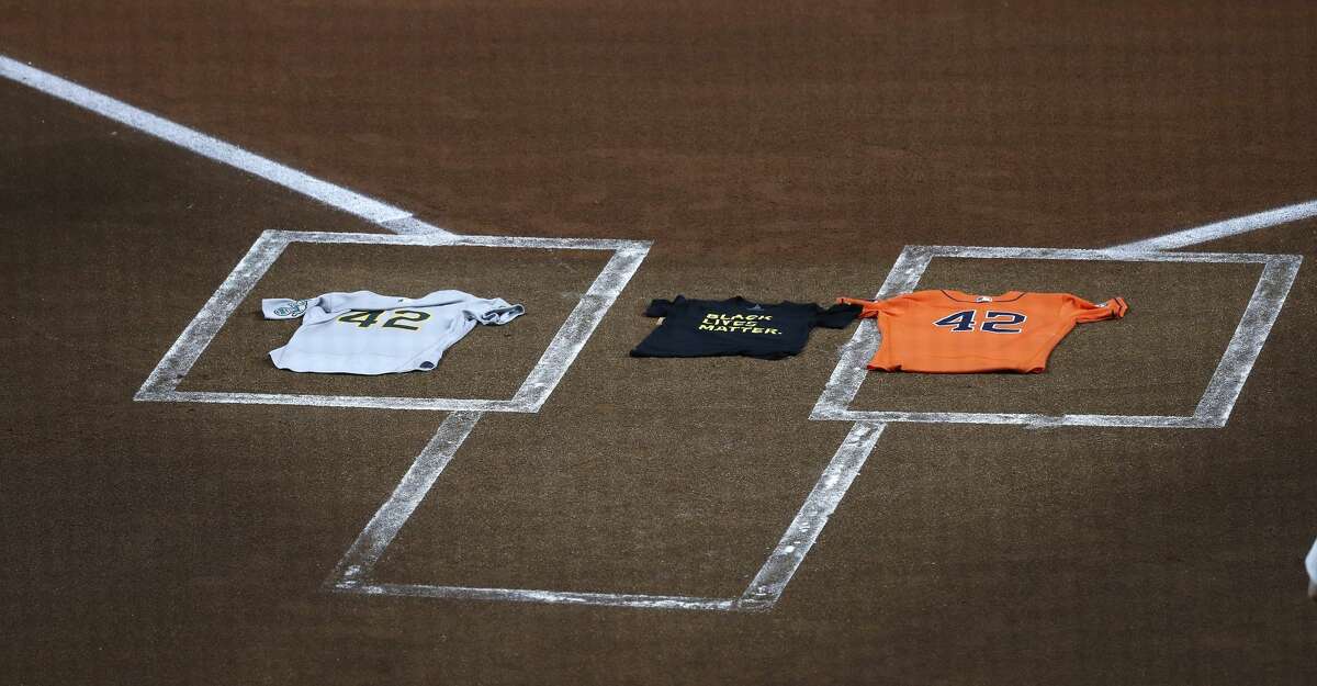 Two "42" jerseys and a Black Lives Matter t-shirt lie on home plate after both teams protested racial injustice and police brutality before an MLB baseball game at Minute Maid Park, Friday, August 28, 2020, in Houston. All players for this game are wearing number 42 tonight, for Jackie Robinson Day. Moments later, all players from both teams exited the field to protest racial injustice and police brutality. Jerseys with "42" and "Black Lives Matter" were placed on home plate.