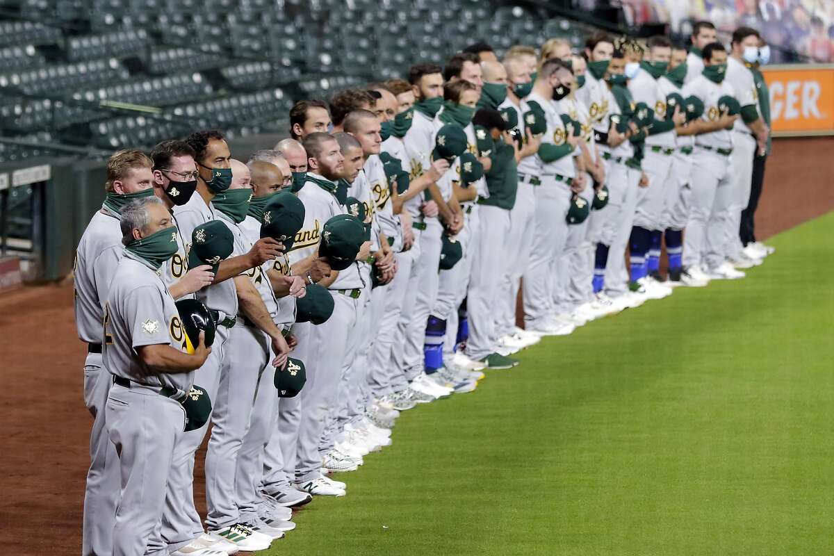 After a moment of silence, Oakland Athletics players wave their hats to the Houston Astros before walking off the field in protest of racial injustice before the start of their baseball game Friday, Aug. 28, 2020, in Houston. (AP Photo/Michael Wyke)