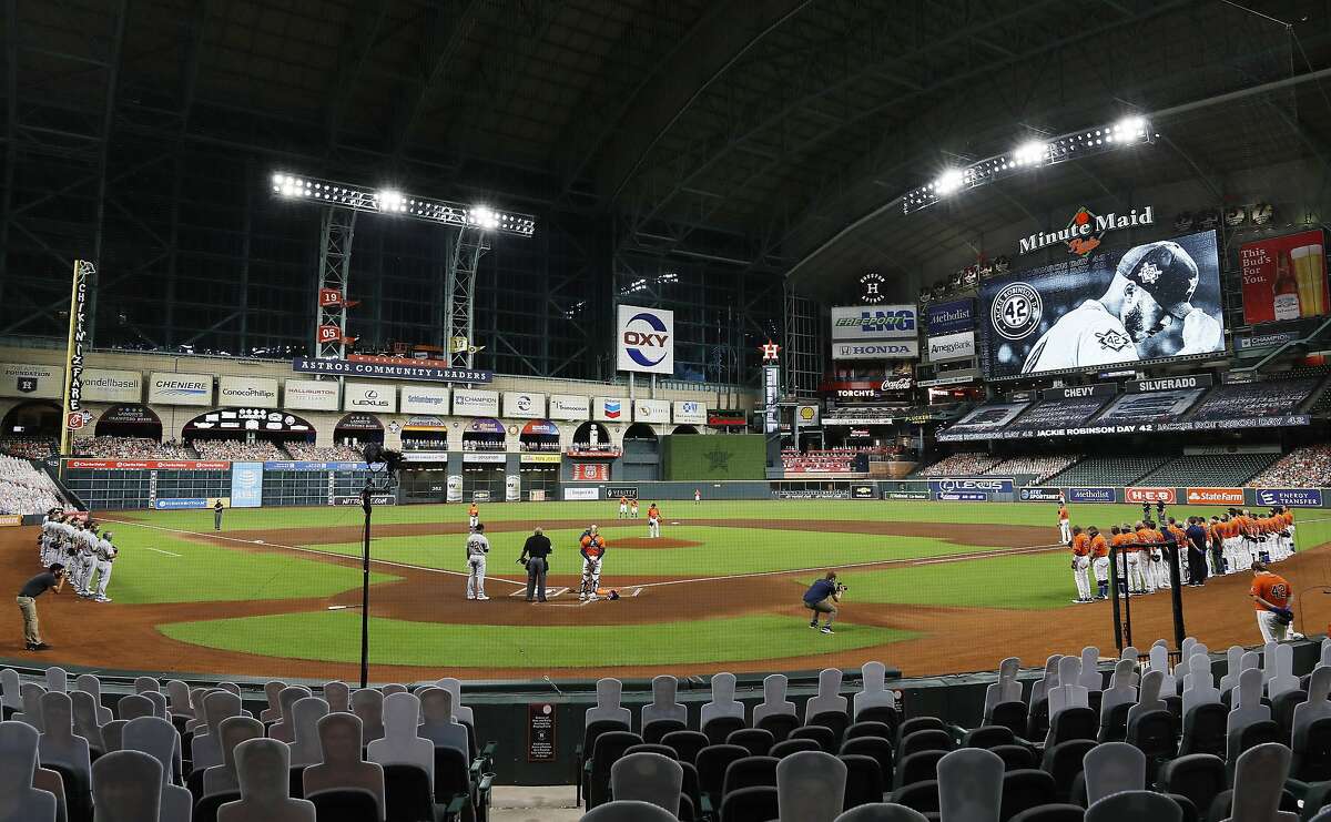 The Oakland Athletics and the Houston Astros stand together in a moment of silence before leaving the field without playing their scheduled baseball game in a protest of racial injustice Friday, Aug. 28, 2020, in Houston. (Kevin M. Cox/The Galveston County Daily News via AP)