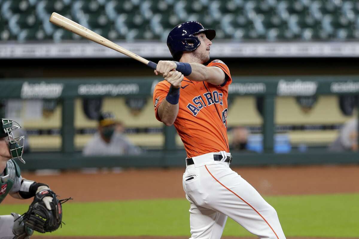 Houston Astros designated hitter Kyle Tucker, right, watches his three-run home run in front of Oakland Athletics catcher Sean Murphy, left, during the first inning of the first baseball game of a doubleheader Saturday, Aug. 29, 2020, in Houston. (AP Photo/Michael Wyke)
